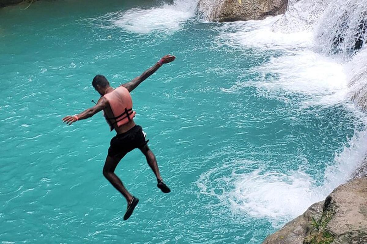 un uomo che salta in acqua da una cascata