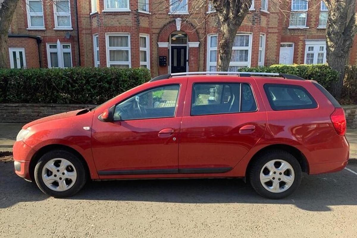 a red car parked in front of a brick building
