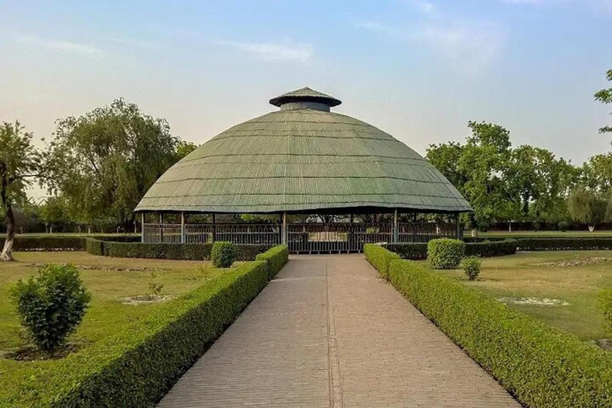 a large building with a green roof in a park