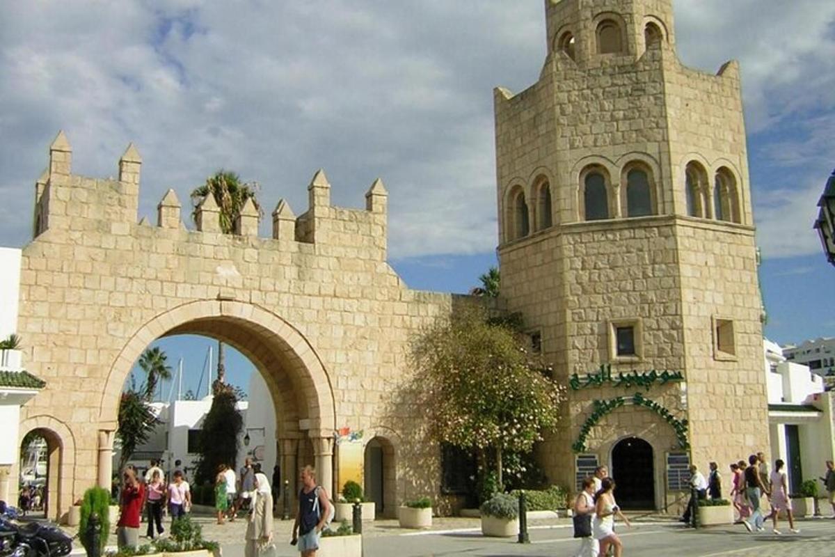 a crowd of people walking around a building with a tower