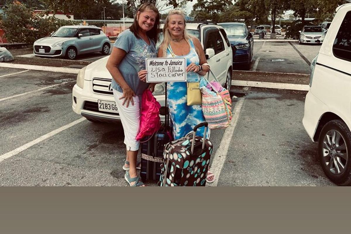 duas mulheres paradas em um estacionamento segurando uma placa