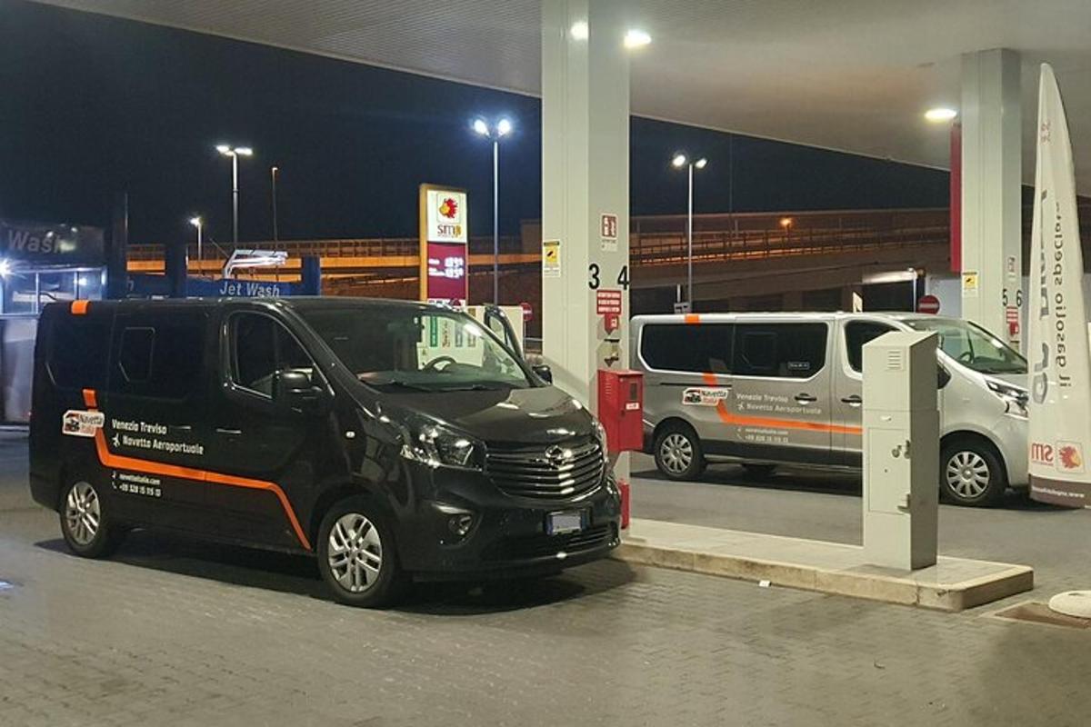 Černá dodávka zaparkovaná v noci u čerpací stanice