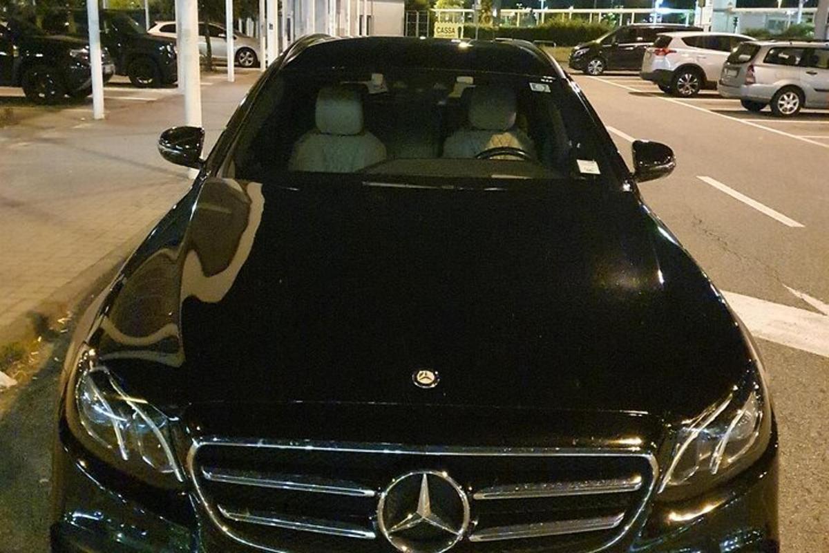 Auto Acedes Benz zaparkované na parkovišti se dvěma lidmi