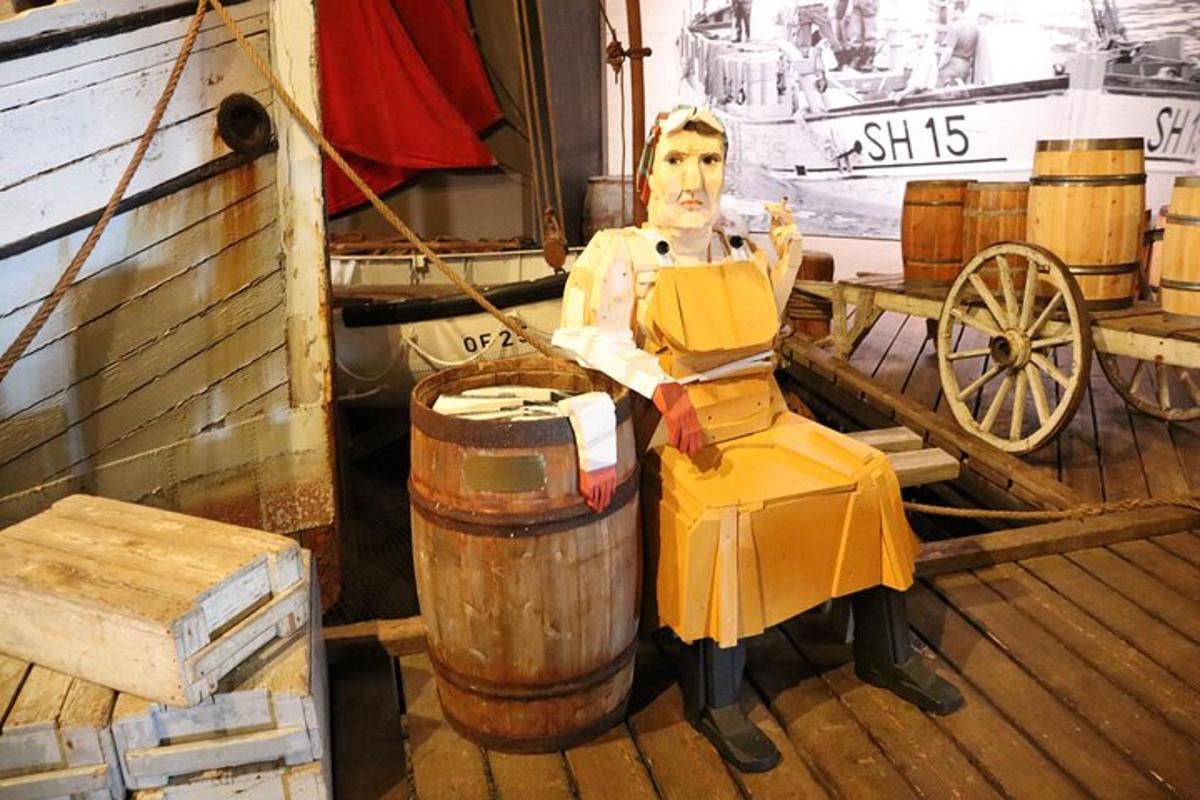 uma estátua de um homem sentado ao lado de um barril