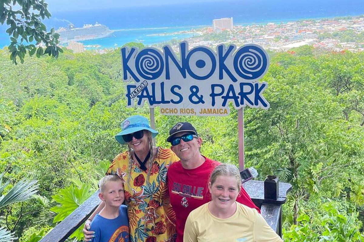 en familie poserer for et bilde foran Koko Falls og park
