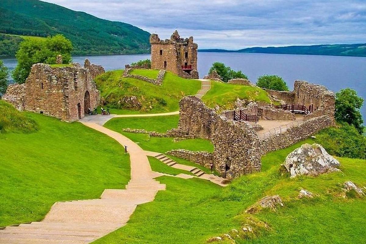 un vecchio castello su una collina accanto a uno specchio d'acqua