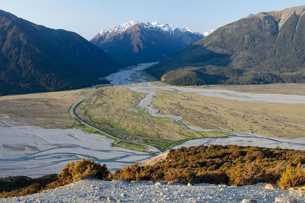 an aerial view of a valley with snow covered mountains