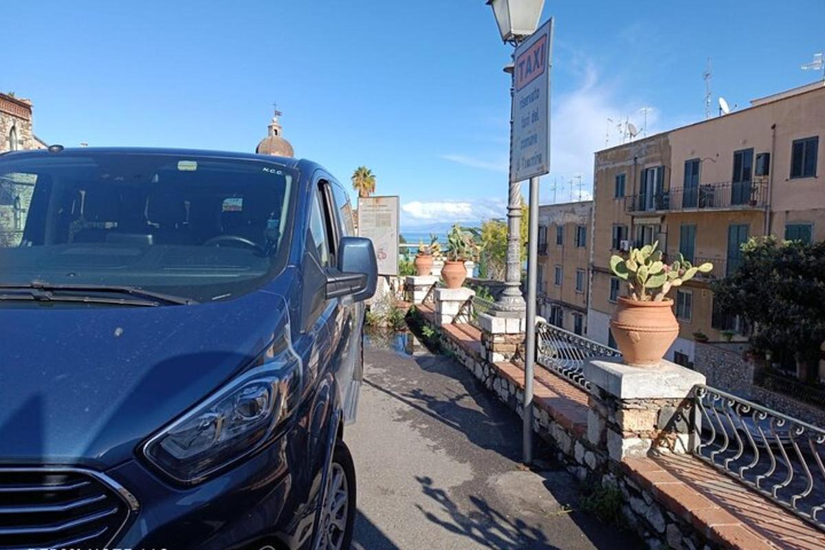 ein blaues Auto, das neben einem Straßenschild geparkt ist