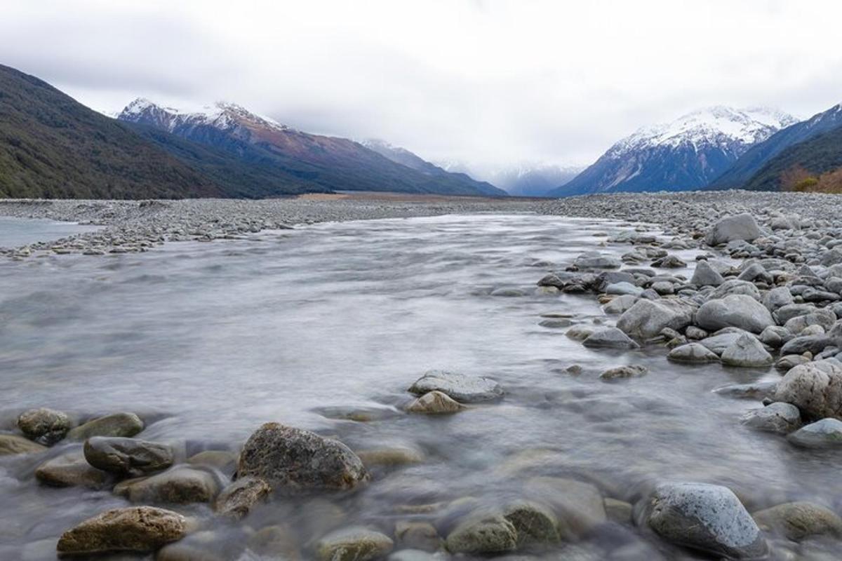 a river with rocks and mountains in the background