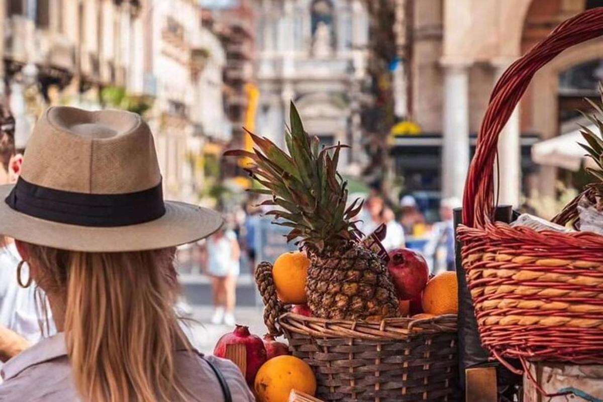 una dona amb un barret i una cistella de fruita