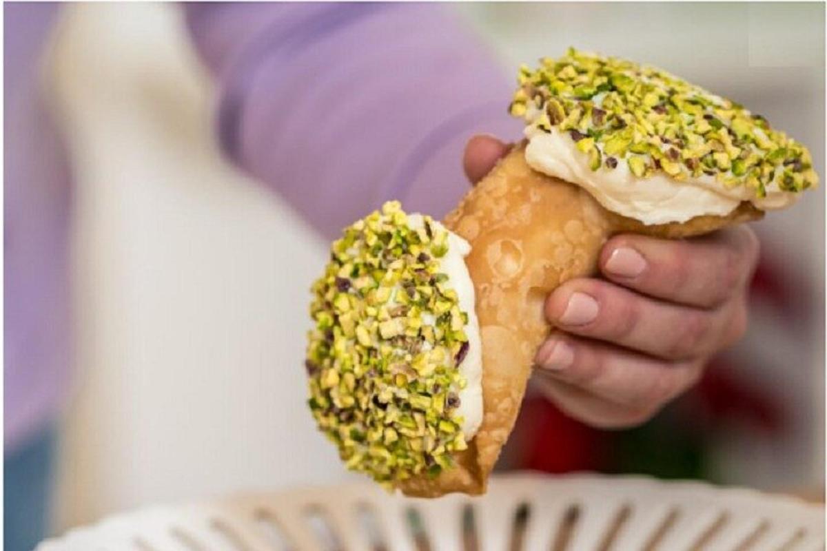 egy személy, aki egy fánkot tart dióval