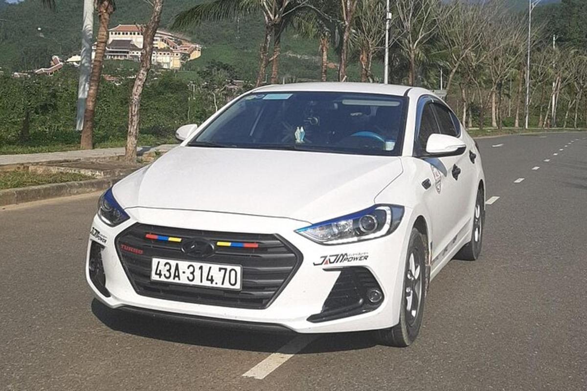 sebuah kereta putih sedang memandu di jalan raya