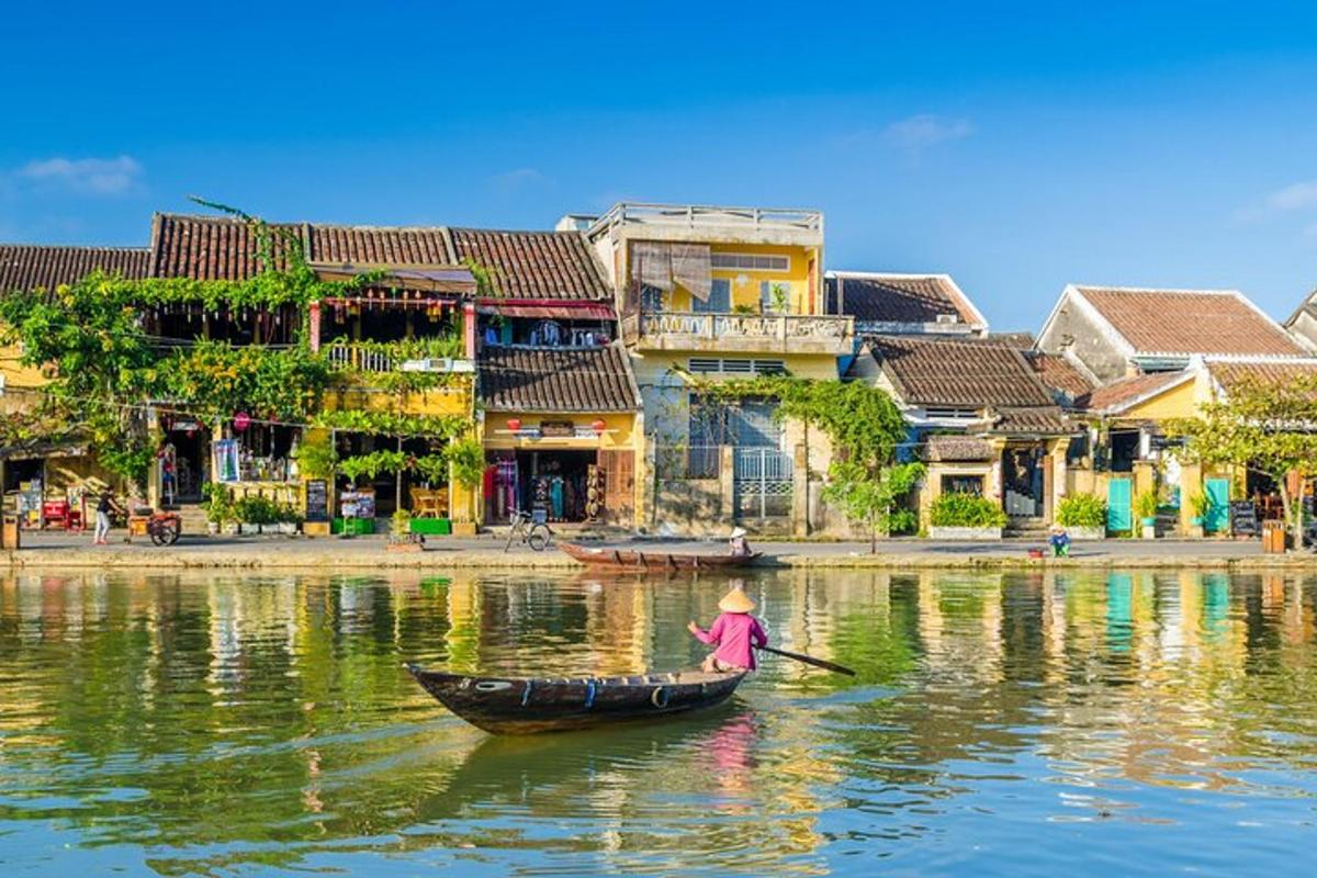 a person in a boat on a river with buildings