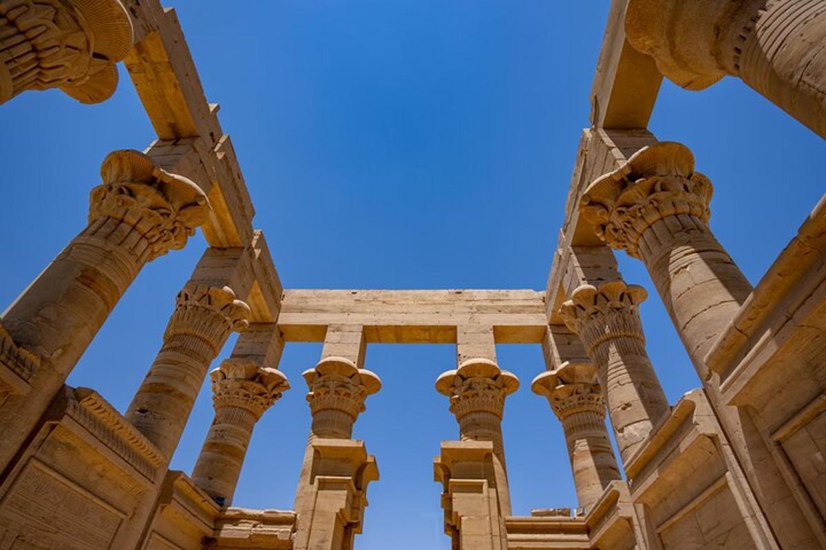 Columnas antiguas de un edificio con un cielo azul al fondo