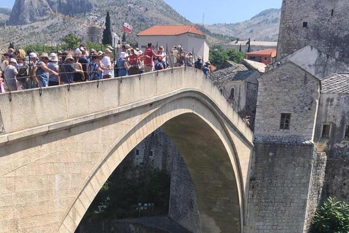 skupina ljudi, ki stojijo na mostu