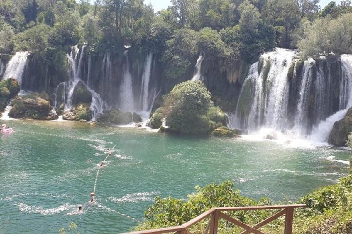 una cascata di fronte a uno specchio d'acqua