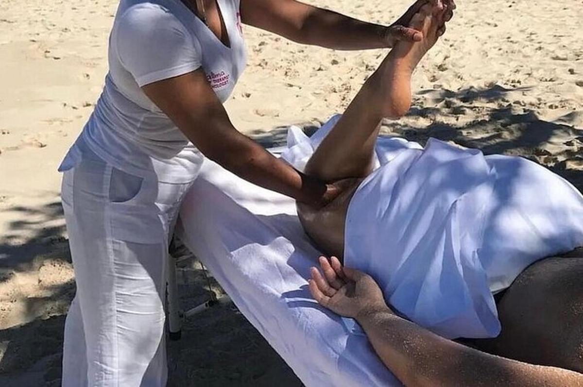 seorang wanita di pantai mendapatkan urutan kaki