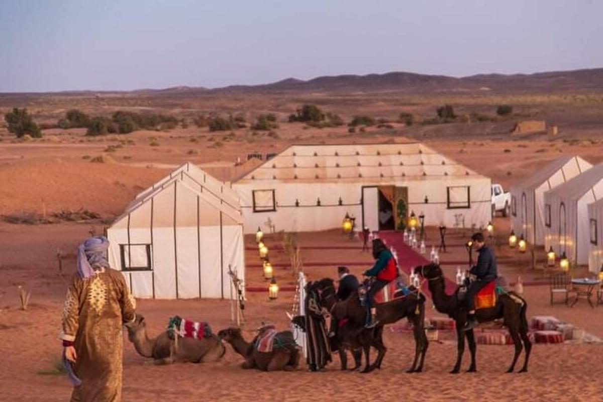 a group of people riding horses in the desert