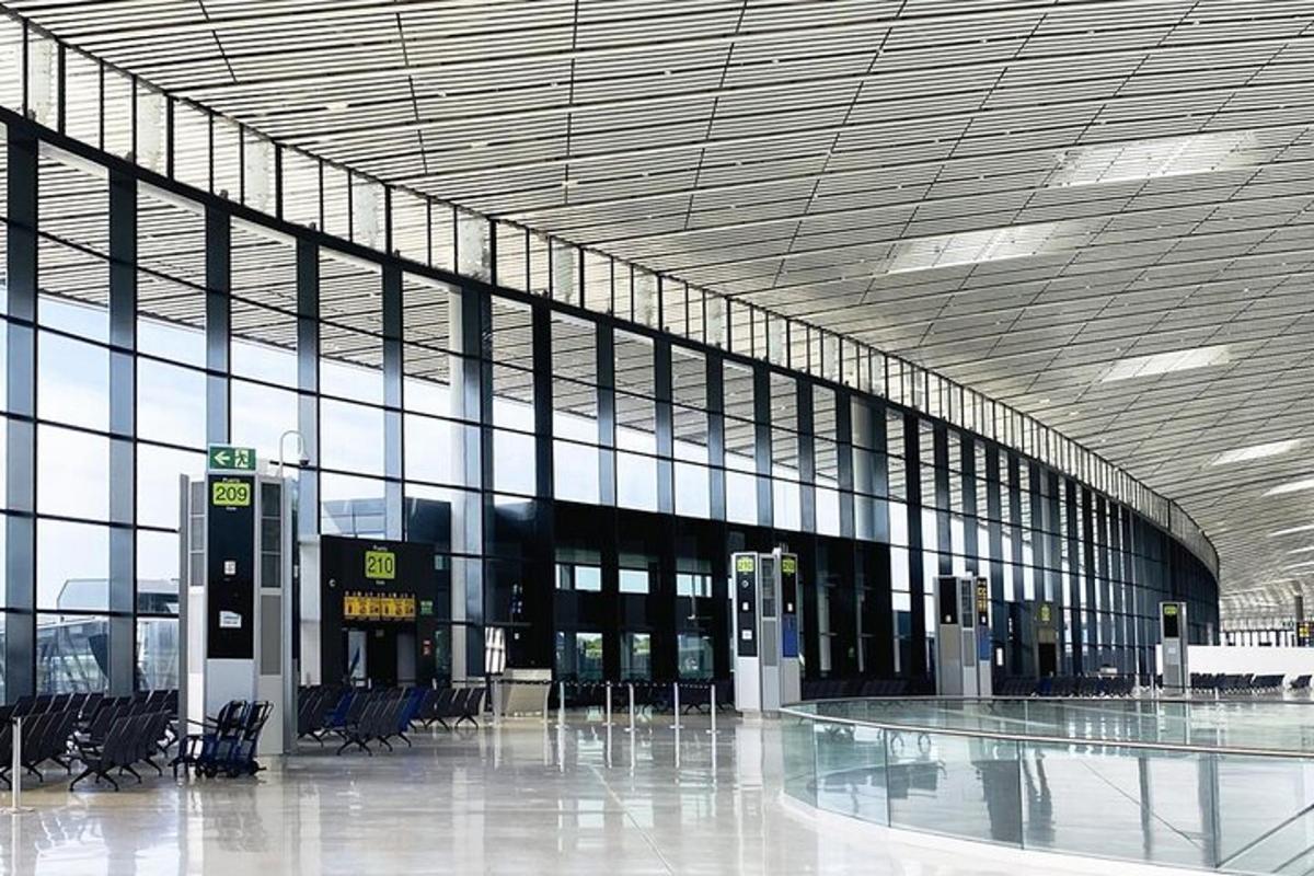 una terminal d'aeroport buida amb un gran edifici amb finestres