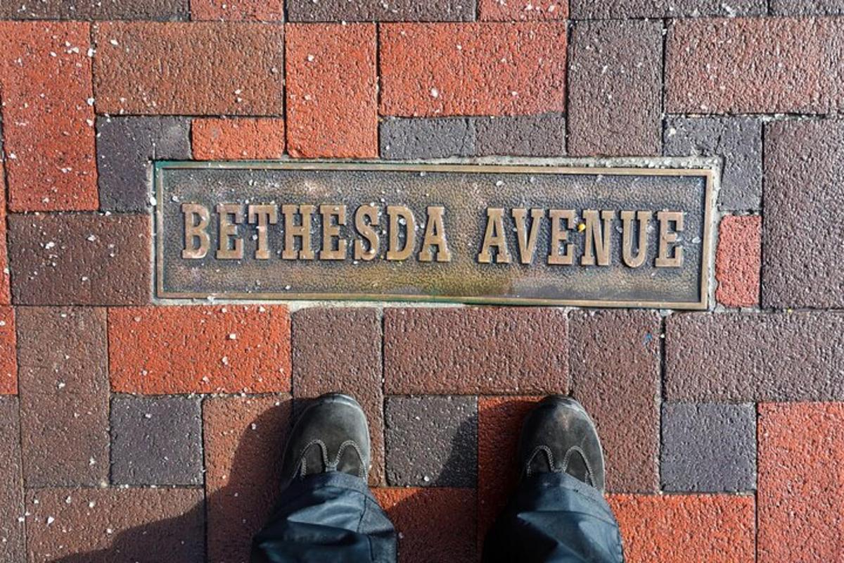una persona in piedi davanti a un cartello su un muro di mattoni