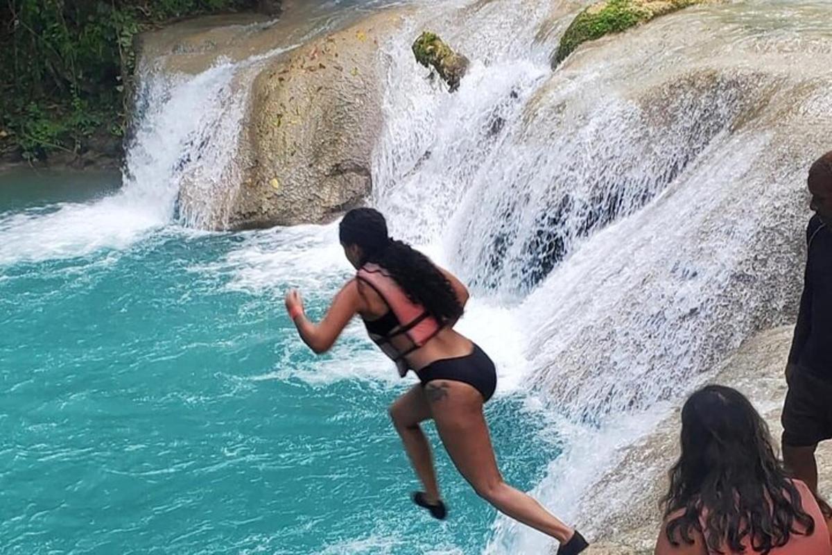 egy bikinis nő ugrik bele egy vízesésbe