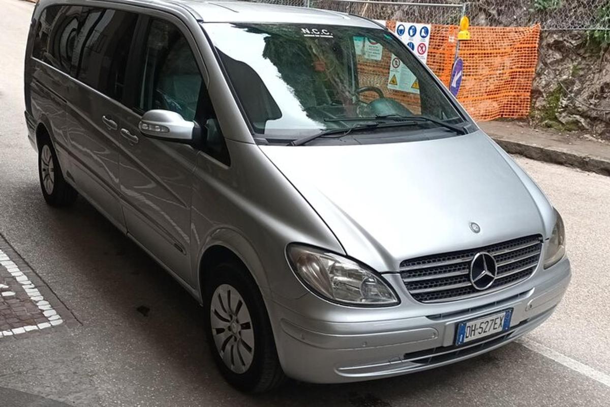 hopeanvärinen pakettiauto pysäköitynä parkkipaikalle