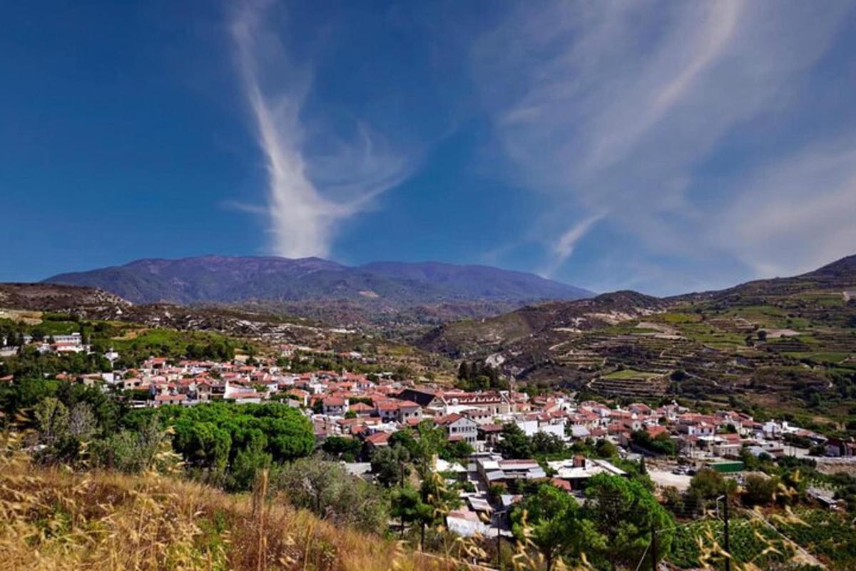 a town on a hill with mountains in the background