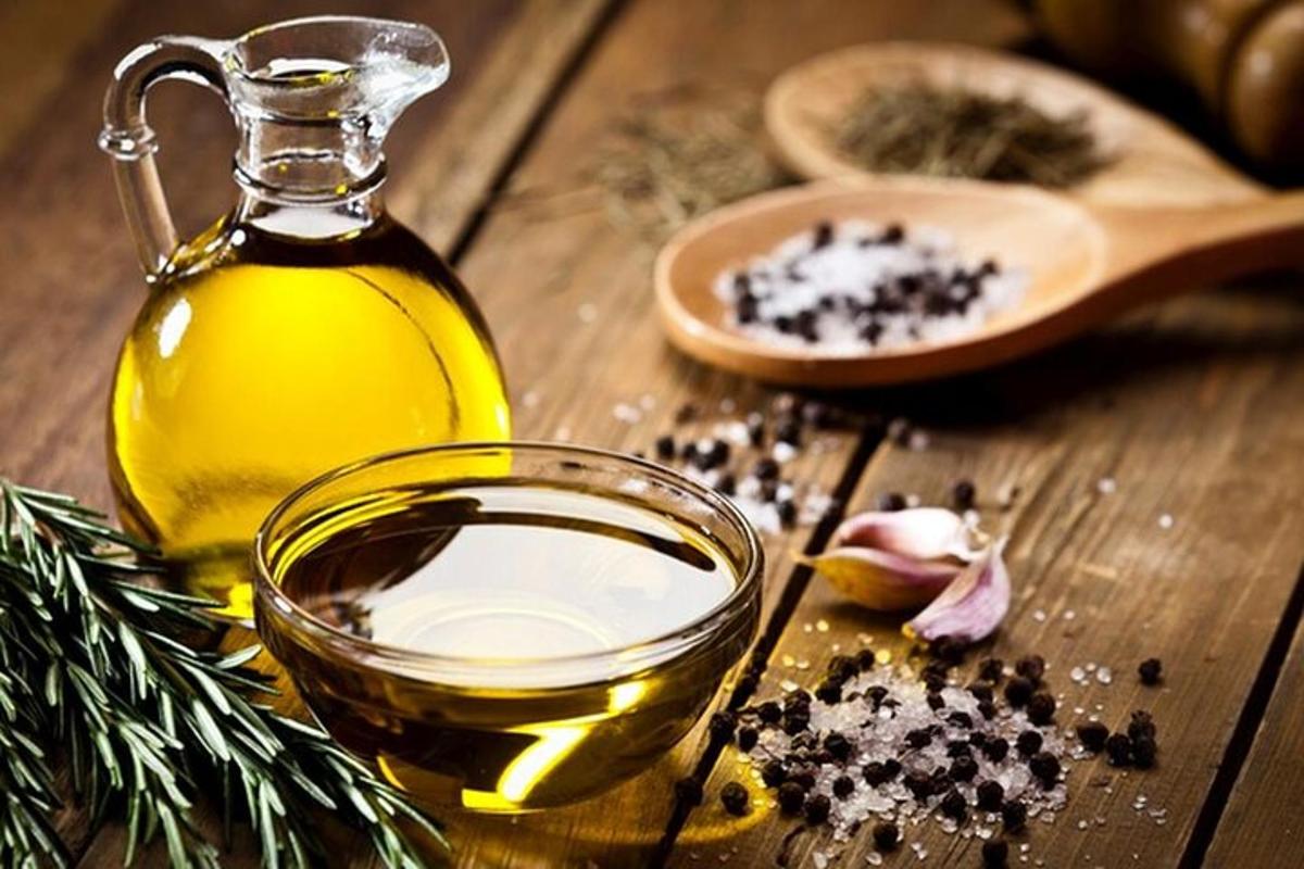 um frasco de vidro com azeite e uma tigela de azeite com uma garrafa ofented