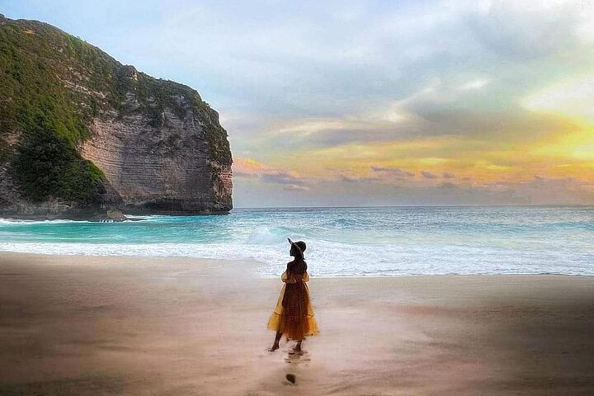seorang wanita berpakaian kuning berdiri di pantai