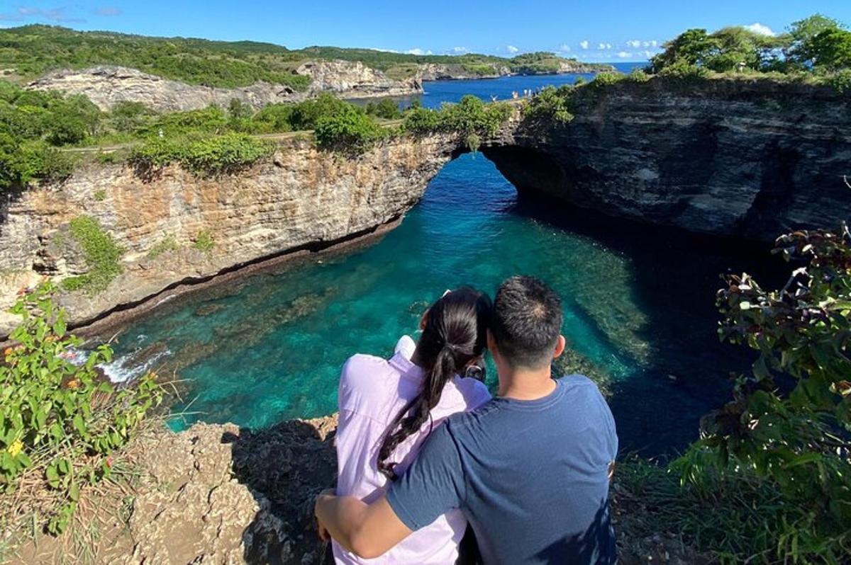 seorang lelaki dan wanita duduk di atas tebing sambil melihat sebuah gua
