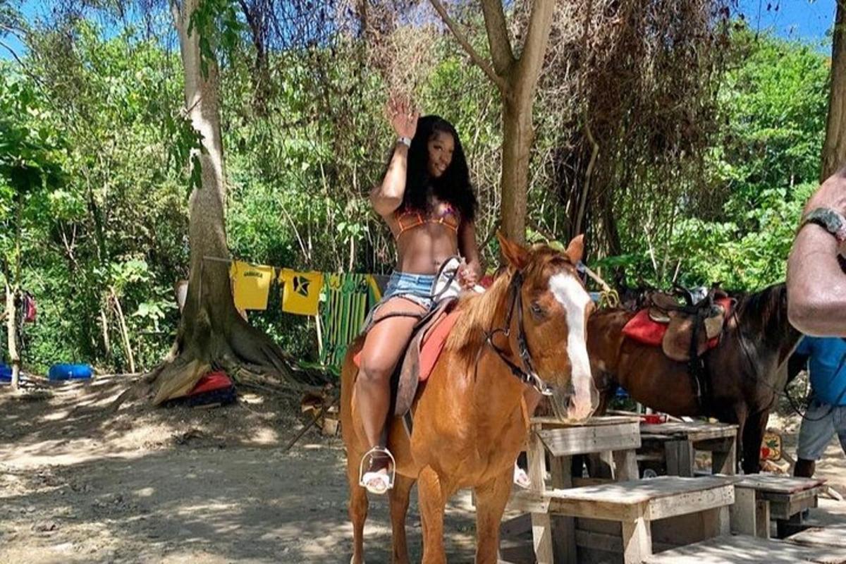 uma mulher de biquíni sentada em um cavalo