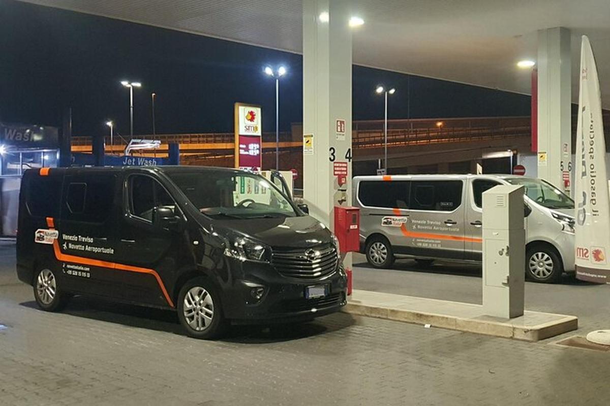 una furgoneta negra aparcada en una gasolinera a la nit