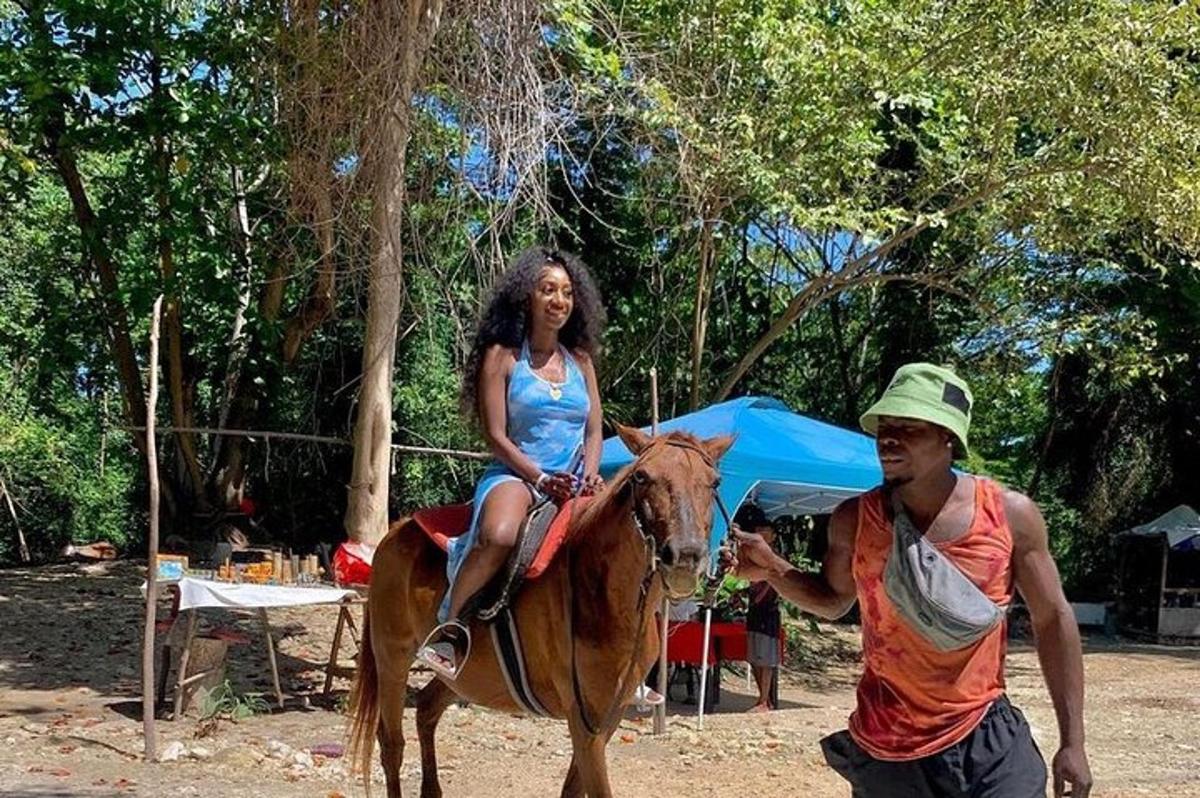 uma mulher está sentada em um cavalo com um homem