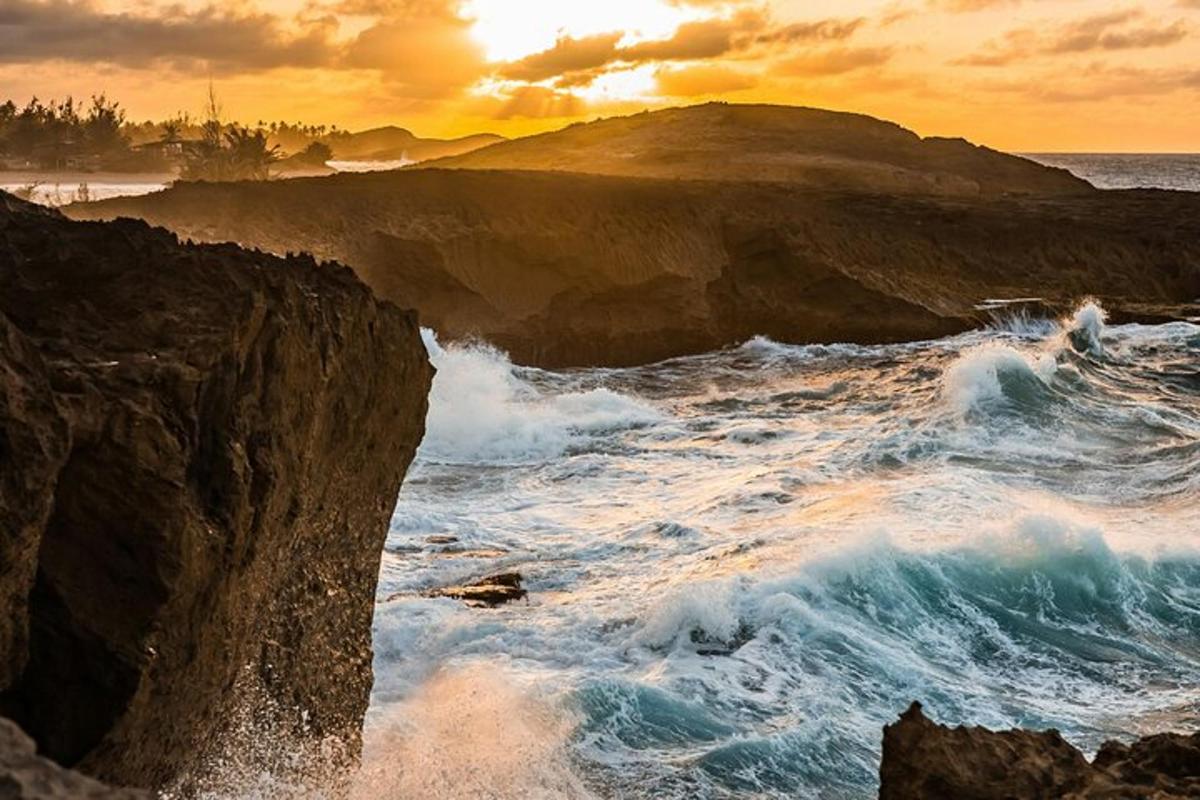 Západ slunce nad oceánem s vlnami a skalami