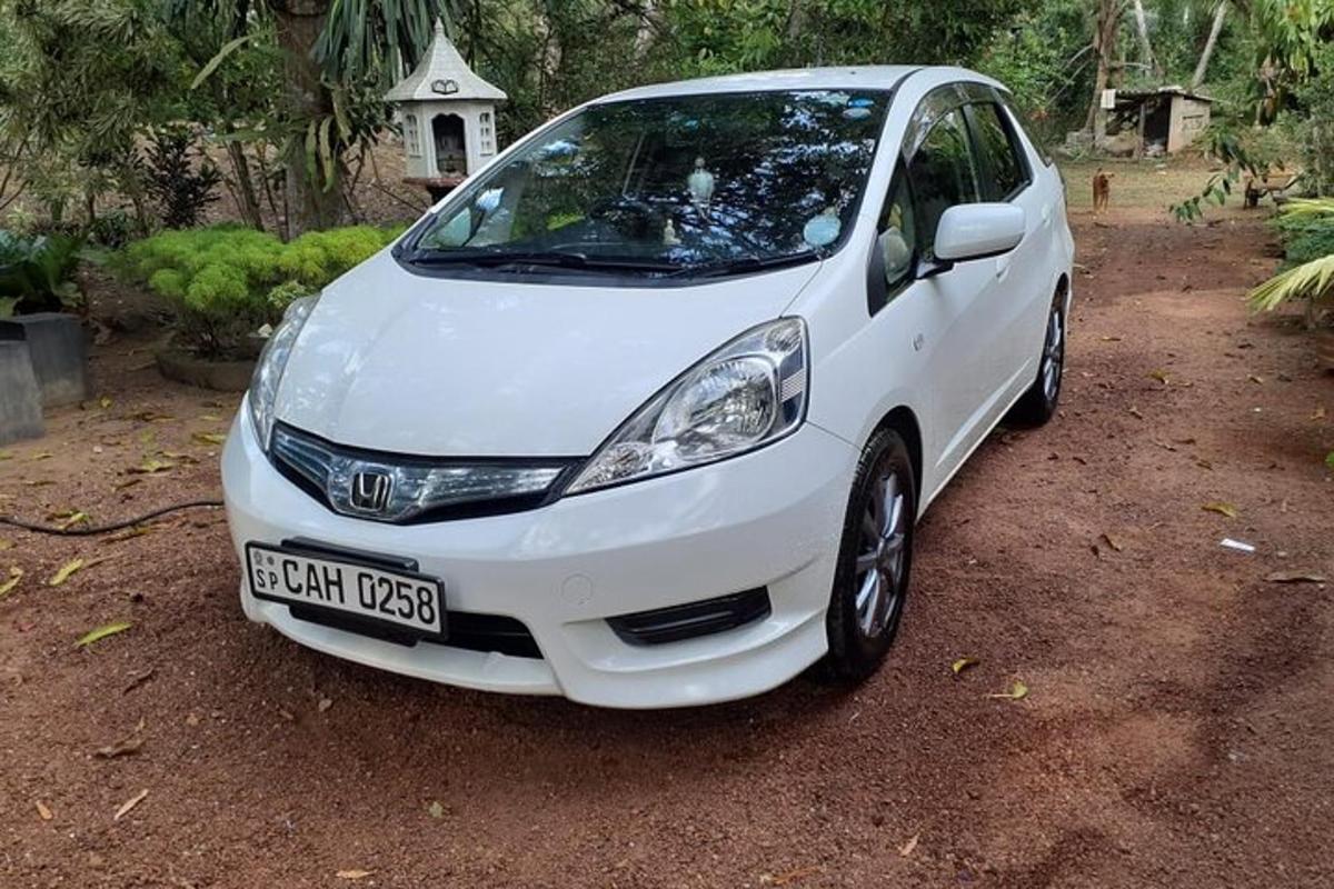 a white car parked in a dirt lot