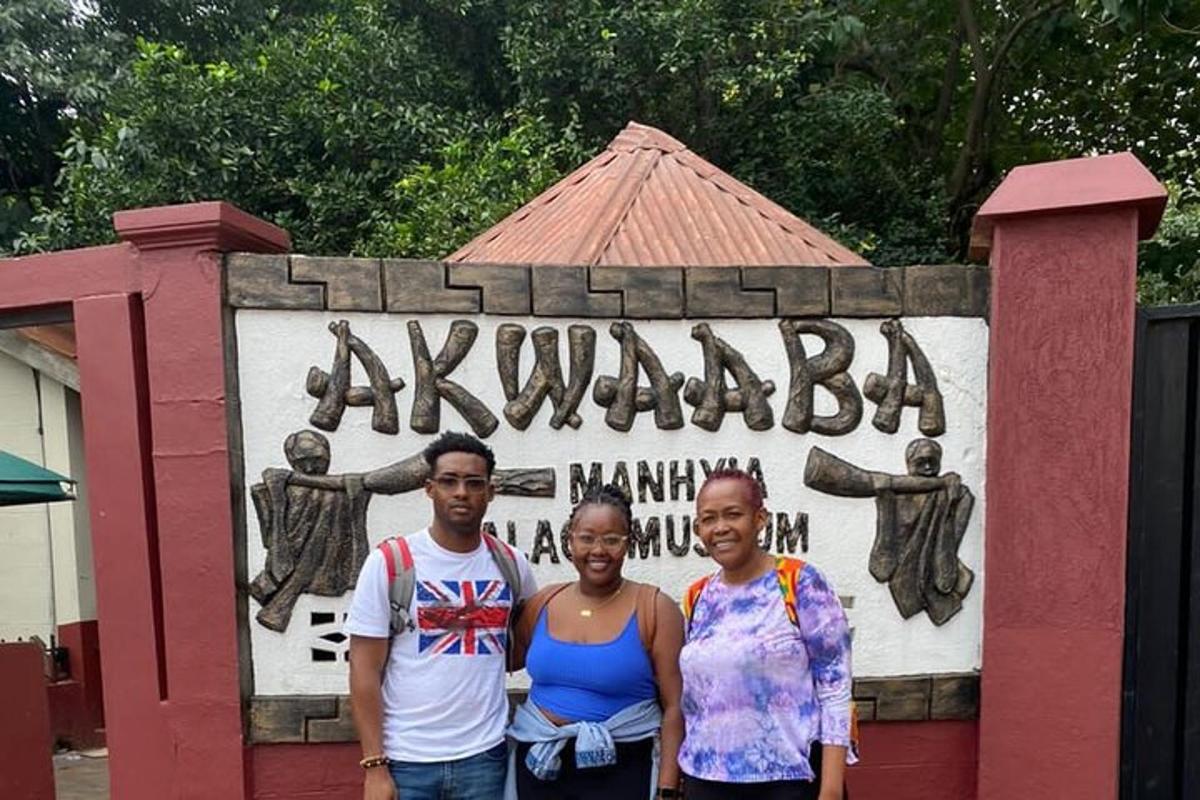 a group of three people standing in front of a sign