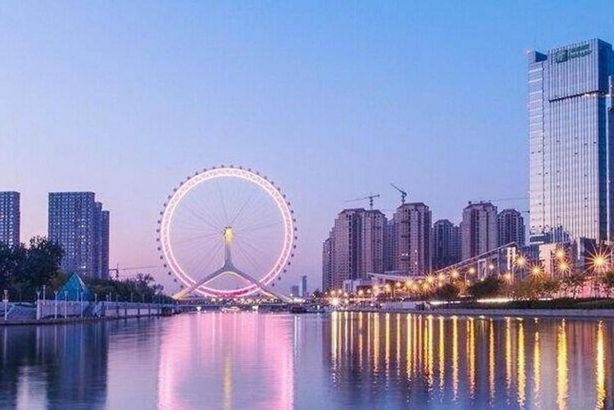 a large ferris wheel in a city with tall buildings