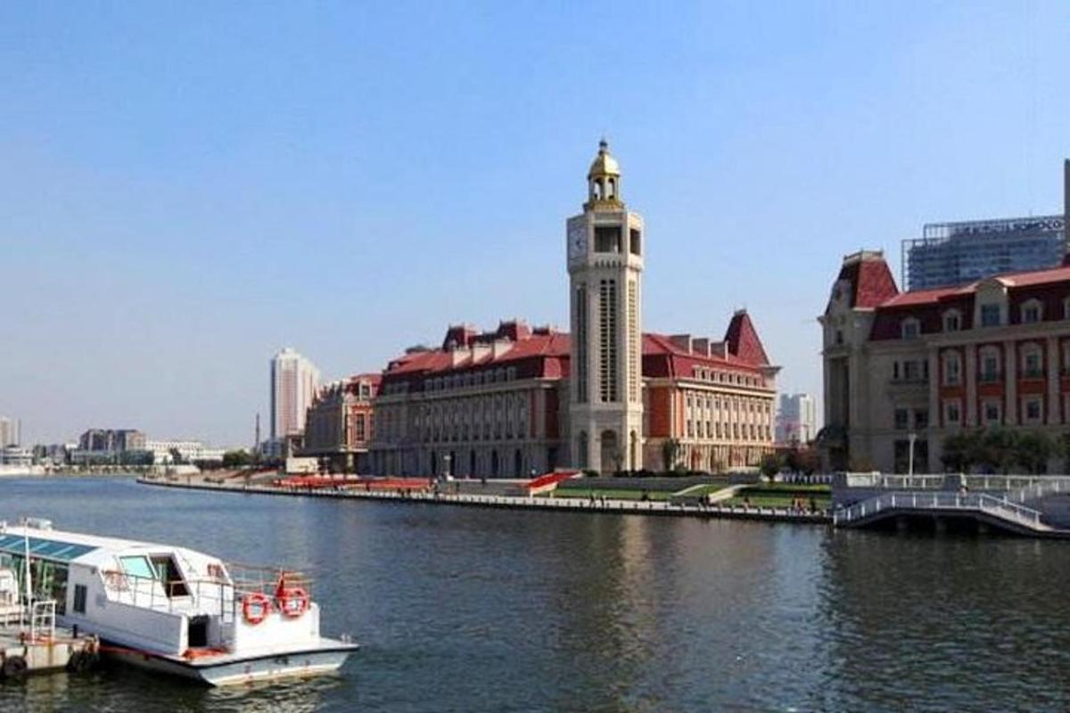 a boat in a river with buildings and a clock tower