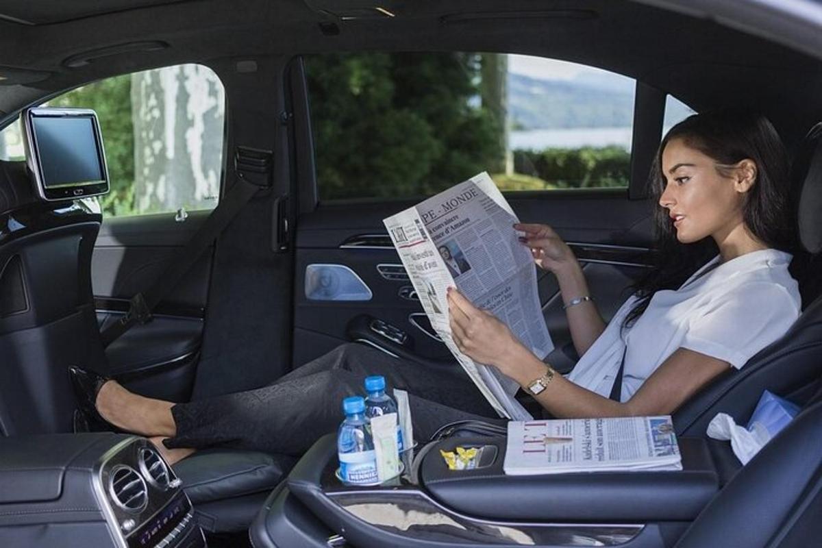 seorang wanita duduk di dalam kereta membaca surat khabar