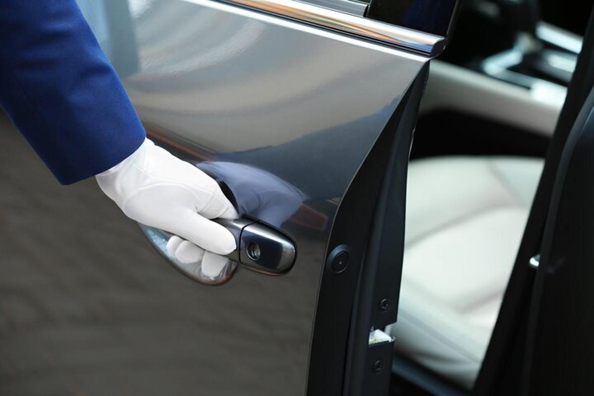 白い手袋をはめた人が車のドアの鍵を開けている