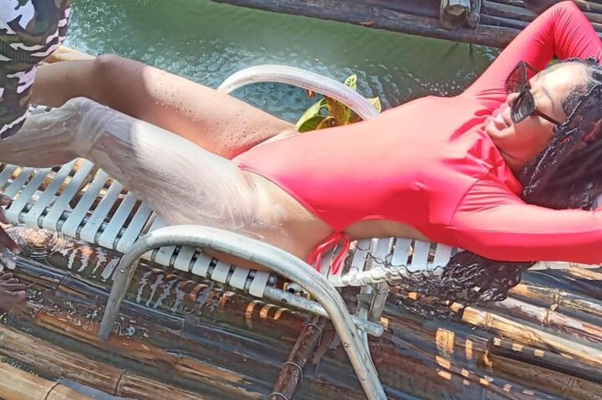 žena v bikinách ležící na lavičce