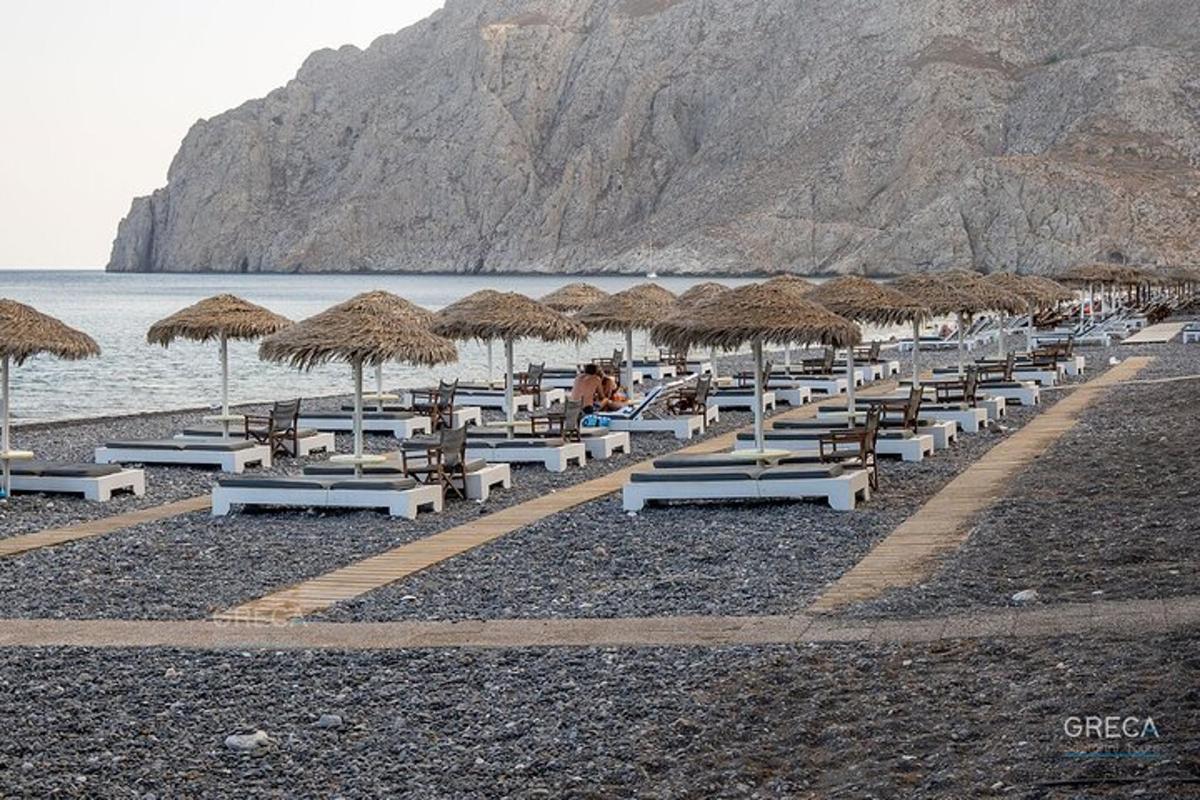 o plajă cu șezlonguri și umbrele de paie și oceanul