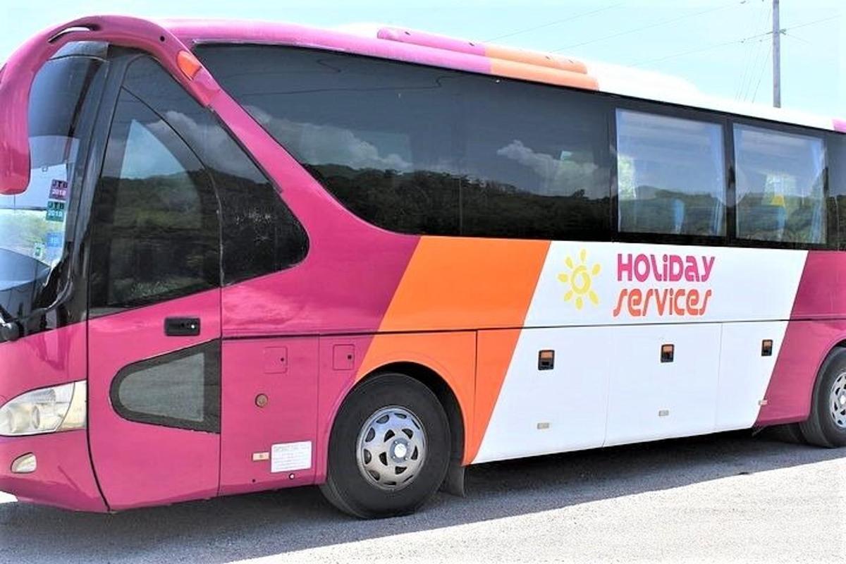 駐車場に停まっているピンクとオレンジ色のバス