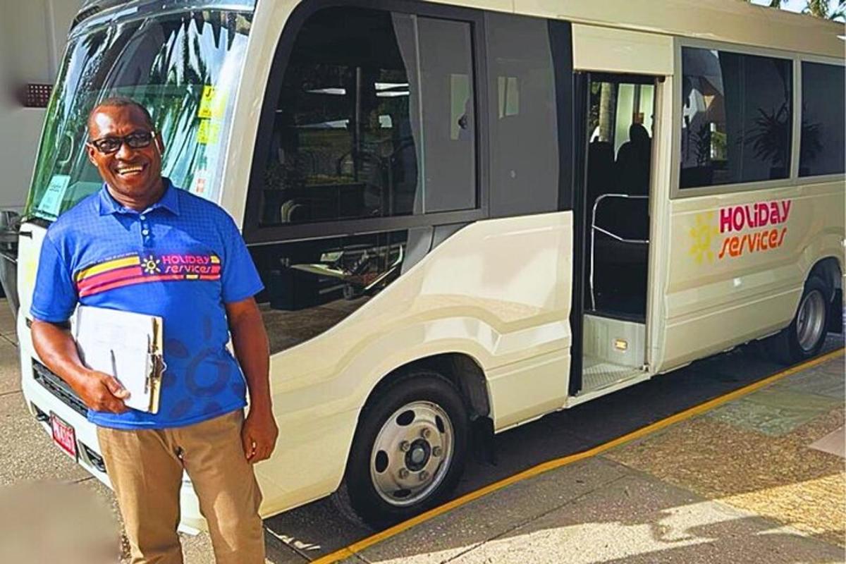 muž stojí pred autobusom