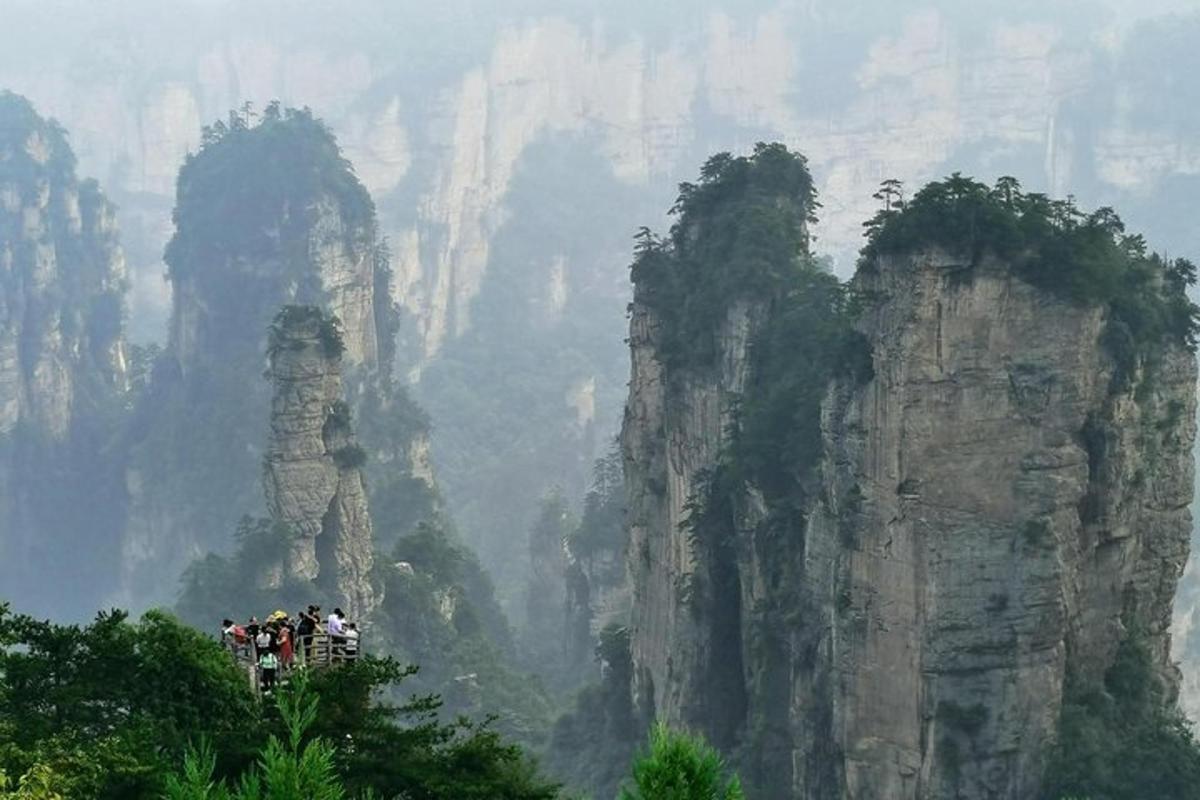 a group of people standing in front of cliffs