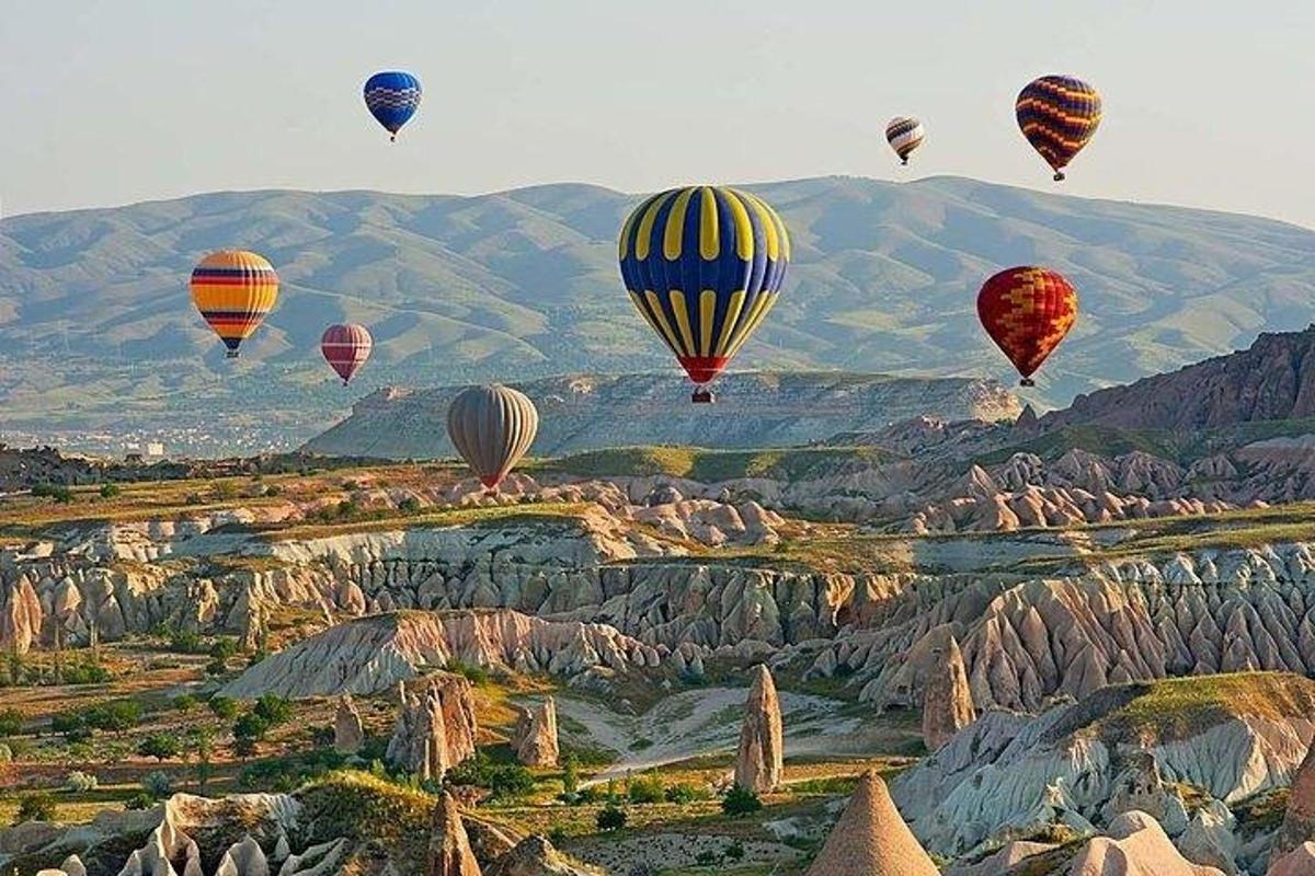 група повітряних куль, що летять над скелями