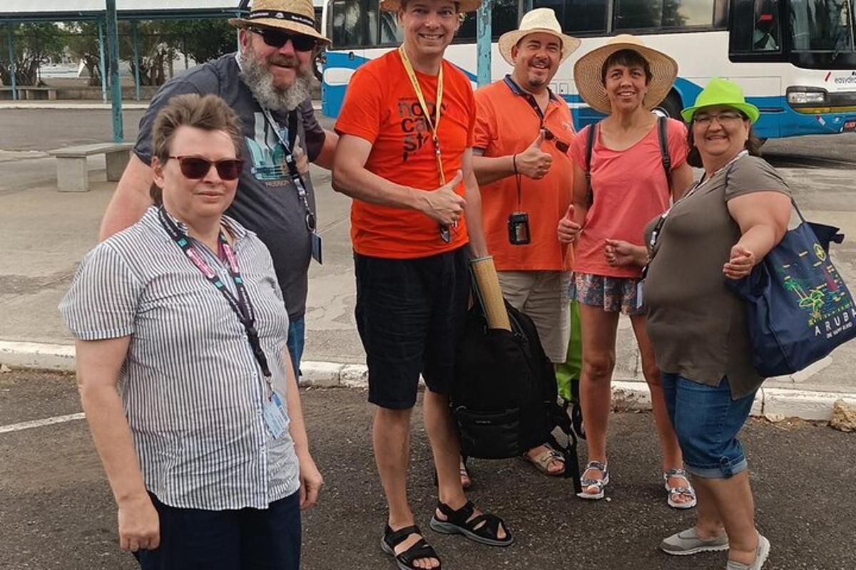 um grupo de pessoas em pé na frente de um ônibus
