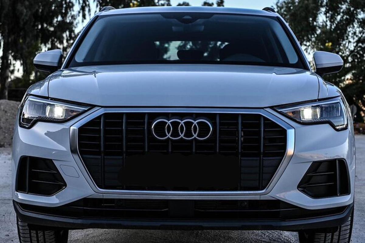 bílé auto značky Audi zaparkované na parkovišti
