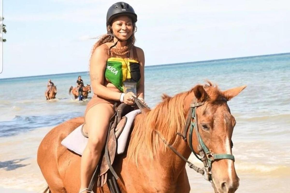 una mujer joven montando a caballo en la playa