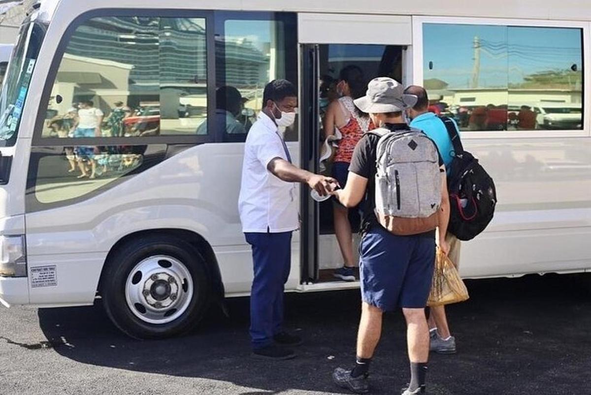 un gruppo di persone che scendono da un autobus bianco